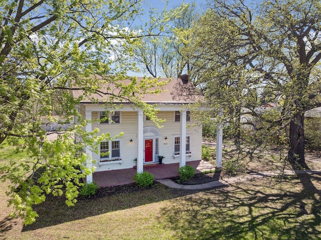 neoclassical / greek revival house featuring a porch and roof with shingles