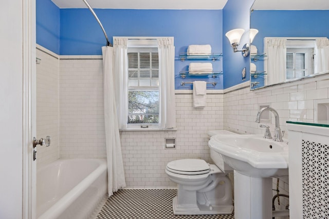 full bathroom with toilet, tile walls, wainscoting, tile patterned flooring, and shower / bathtub combination with curtain