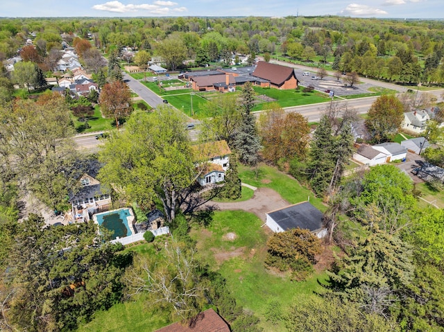 aerial overview of property's location with a pool area, nearby suburban area, and a forest