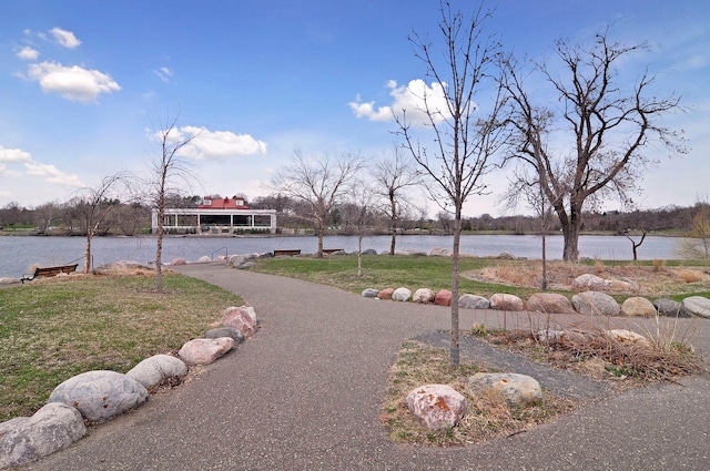 view of home's community with a water view and a yard