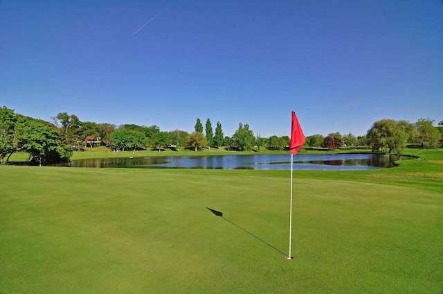 view of property's community featuring a water view, a yard, and golf course view