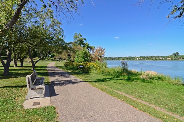surrounding community featuring a water view and a lawn