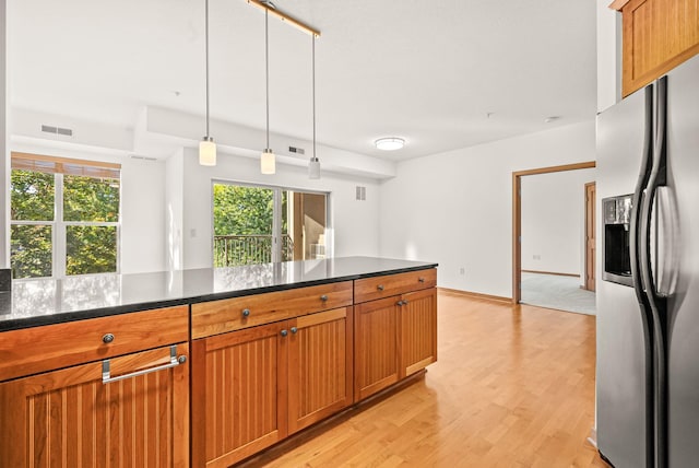 kitchen featuring stainless steel fridge with ice dispenser, pendant lighting, and light hardwood / wood-style floors