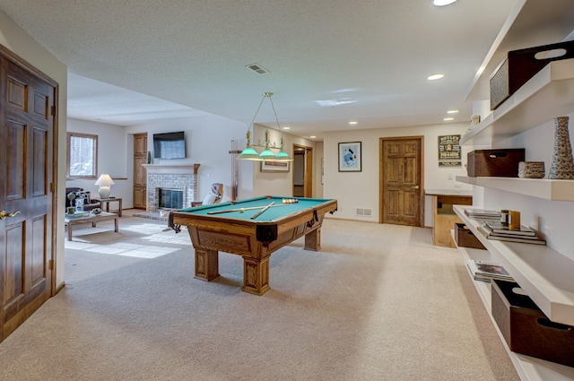 rec room featuring pool table, light carpet, a fireplace, and a textured ceiling