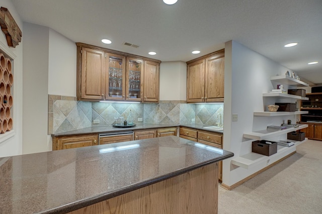 kitchen with sink, decorative backsplash, and dark stone countertops