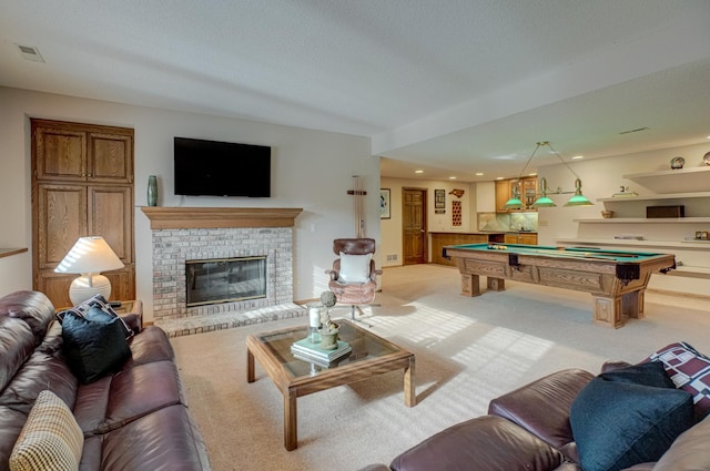 living room featuring pool table, a textured ceiling, wood walls, a brick fireplace, and light colored carpet