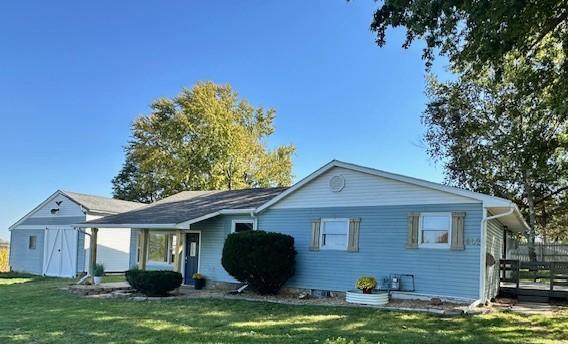 back of house with a wooden deck and a lawn