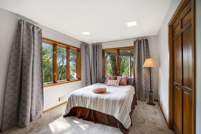 carpeted bedroom featuring a textured ceiling and a closet