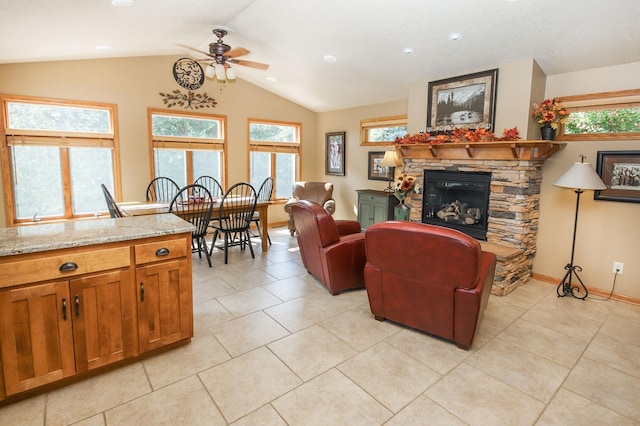 living room featuring a fireplace, ceiling fan, lofted ceiling, and a wealth of natural light