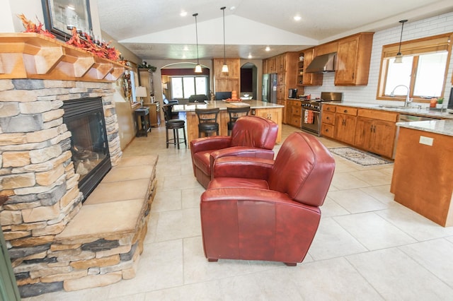 living room with lofted ceiling, sink, light tile patterned floors, and a fireplace