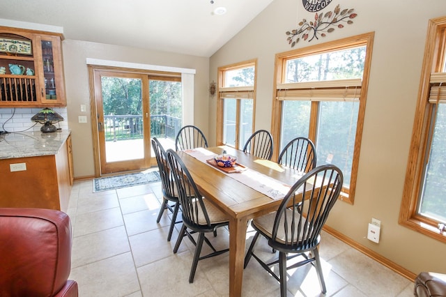 tiled dining space with lofted ceiling