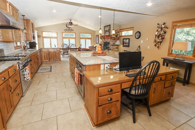 kitchen featuring stainless steel stove, a kitchen breakfast bar, light stone counters, pendant lighting, and a kitchen island