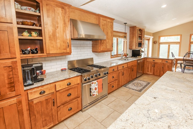 kitchen with sink, light stone counters, pendant lighting, wall chimney range hood, and stainless steel appliances