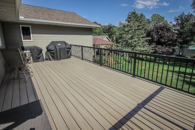 wooden deck with a yard and area for grilling