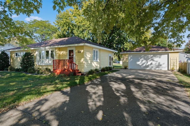 ranch-style house featuring a garage, a front lawn, and an outbuilding