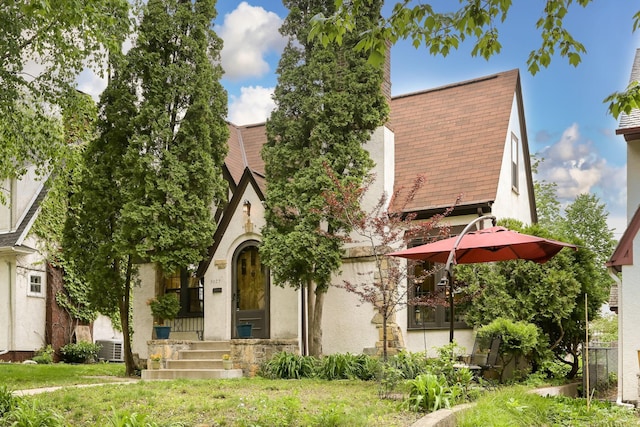 5025 16th Ave S, Minneapolis, MN 55417 - tudor-style house with stucco siding, central AC unit, and a front lawn