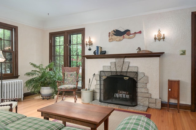 5025 16th Ave S, Minneapolis, MN 55417 - living area with radiator, wood finished floors, a fireplace with raised hearth, and baseboards