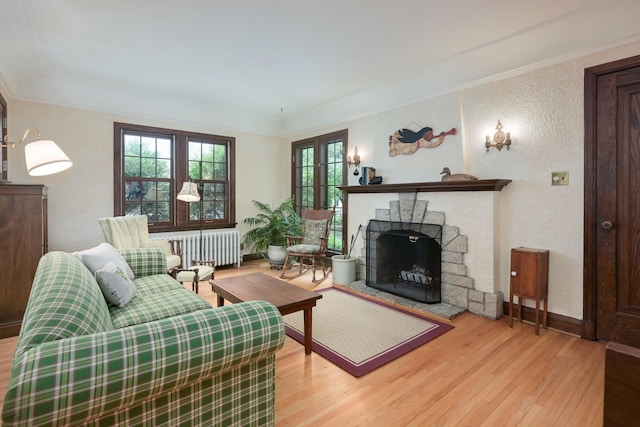 5025 16th Ave S, Minneapolis, MN 55417 - living room with radiator heating unit, wood-type flooring, a textured wall, a stone fireplace, and crown molding
