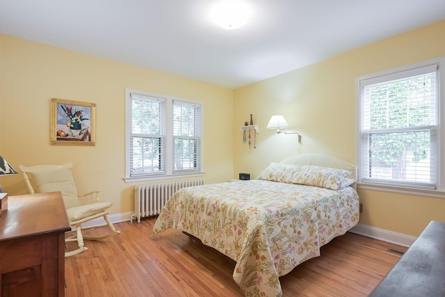 5025 16th Ave S, Minneapolis, MN 55417 - bedroom with radiator, multiple windows, and light wood finished floors