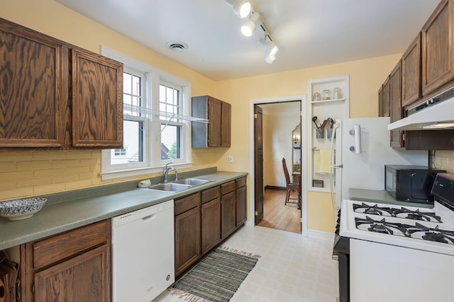 5025 16th Ave S, Minneapolis, MN 55417 - kitchen with white dishwasher, gas range, a sink, under cabinet range hood, and tasteful backsplash