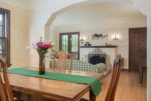 5025 16th Ave S, Minneapolis, MN 55417 - dining area featuring light wood-style floors, a fireplace, and arched walkways