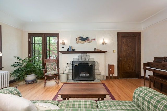 5025 16th Ave S, Minneapolis, MN 55417 - living room featuring wood finished floors, radiator heating unit, a fireplace, crown molding, and baseboards