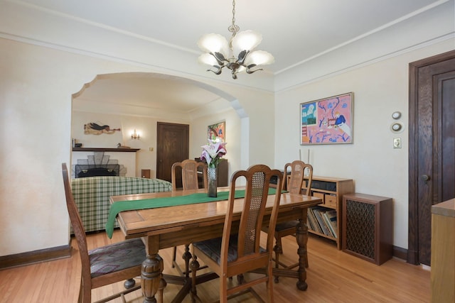 5025 16th Ave S, Minneapolis, MN 55417 - dining room featuring arched walkways, a chandelier, light wood-type flooring, baseboards, and ornamental molding