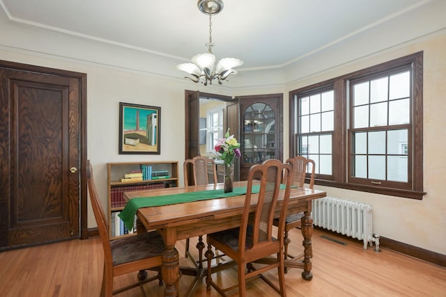 5025 16th Ave S, Minneapolis, MN 55417 - dining room featuring radiator, a chandelier, baseboards, light wood-style floors, and crown molding