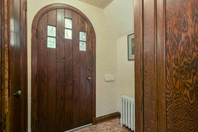 5025 16th Ave S, Minneapolis, MN 55417 - entrance foyer featuring radiator heating unit, a textured wall, arched walkways, and baseboards