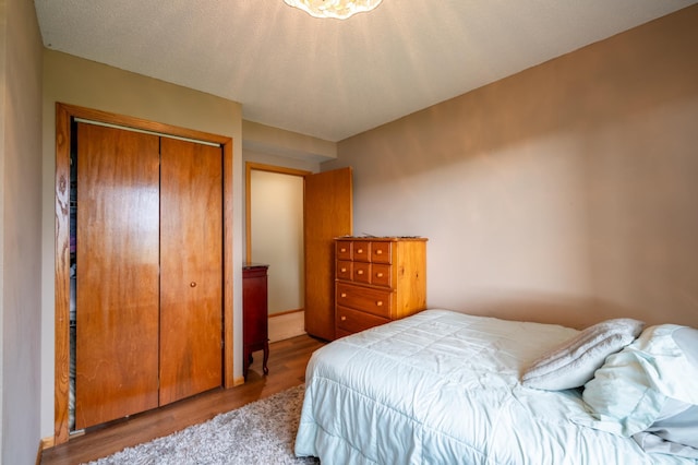 bedroom featuring a textured ceiling, light hardwood / wood-style floors, and a closet