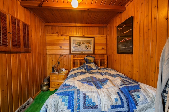 carpeted bedroom featuring wooden walls, beam ceiling, and wooden ceiling