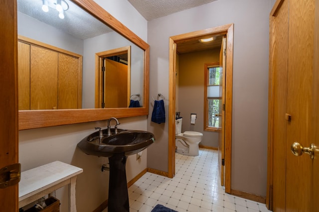 bathroom with a textured ceiling and toilet