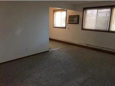 spare room with a wall mounted air conditioner and carpet