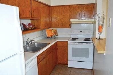 kitchen featuring sink, white appliances, and tile patterned floors