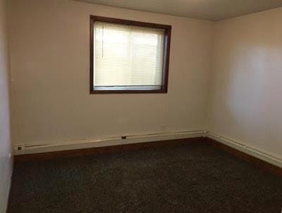 spare room with dark colored carpet