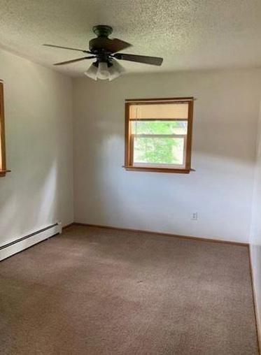 spare room with carpet, ceiling fan, a baseboard heating unit, and a textured ceiling