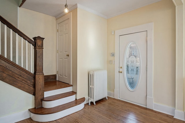 foyer entrance featuring ornamental molding, radiator heating unit, and hardwood / wood-style floors