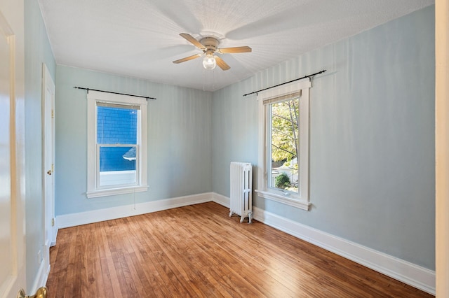 spare room featuring ceiling fan, a textured ceiling, light hardwood / wood-style floors, and radiator