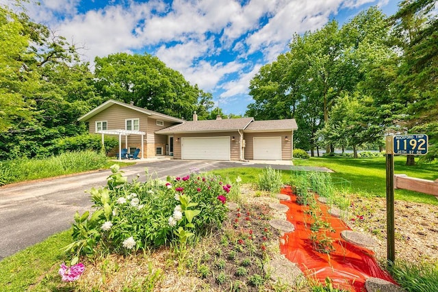 view of front of home with a front lawn, a garage, and a pergola