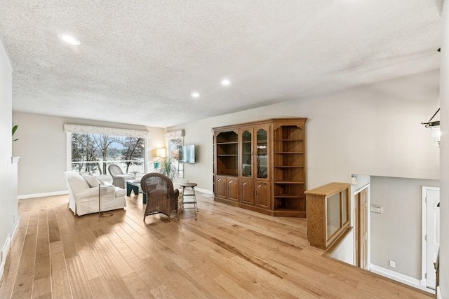 living area with a textured ceiling and light wood-type flooring