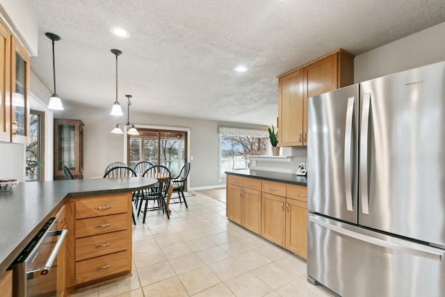 kitchen featuring light tile patterned floors, pendant lighting, a textured ceiling, and stainless steel refrigerator