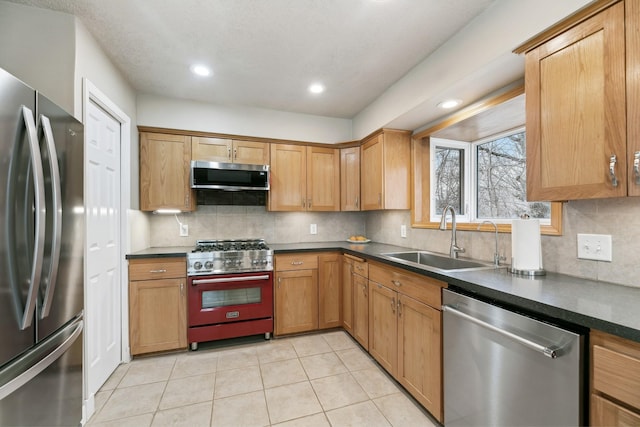 kitchen with sink, stainless steel appliances, light tile patterned flooring, and backsplash