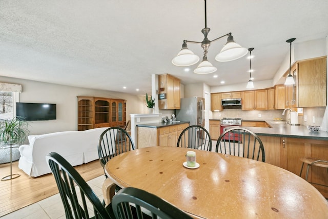 tiled dining area featuring a textured ceiling and sink