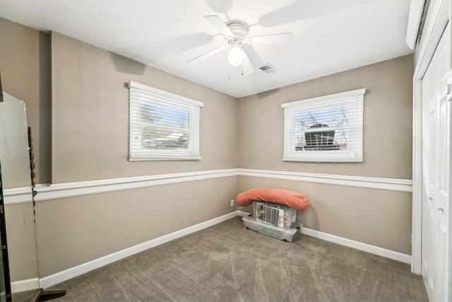 interior space with ceiling fan, a textured ceiling, and carpet flooring