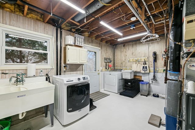 clothes washing area featuring sink, cabinets, and washing machine and dryer