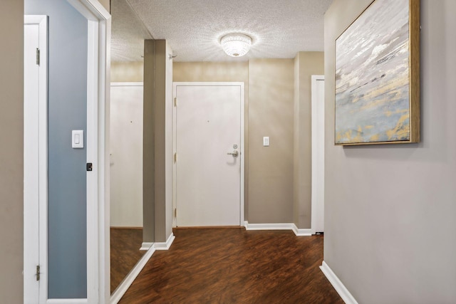 hallway featuring a textured ceiling and dark wood-type flooring