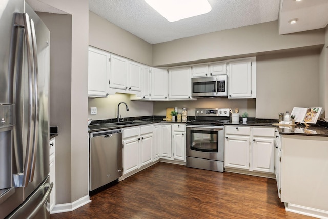 kitchen featuring sink, appliances with stainless steel finishes, a textured ceiling, and white cabinets