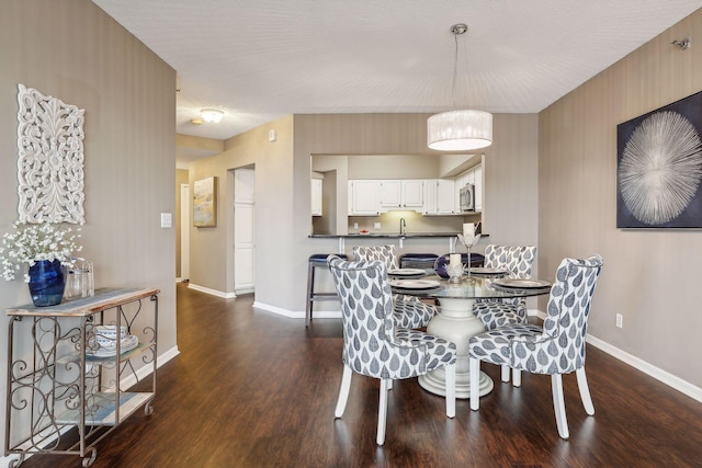 dining area featuring dark hardwood / wood-style floors, a textured ceiling, and sink