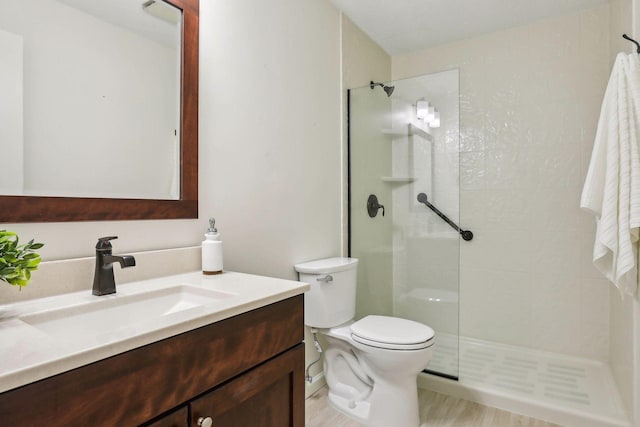 bathroom featuring vanity, a tile shower, hardwood / wood-style flooring, and toilet