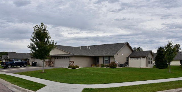 single story home with a garage, a front lawn, and central AC